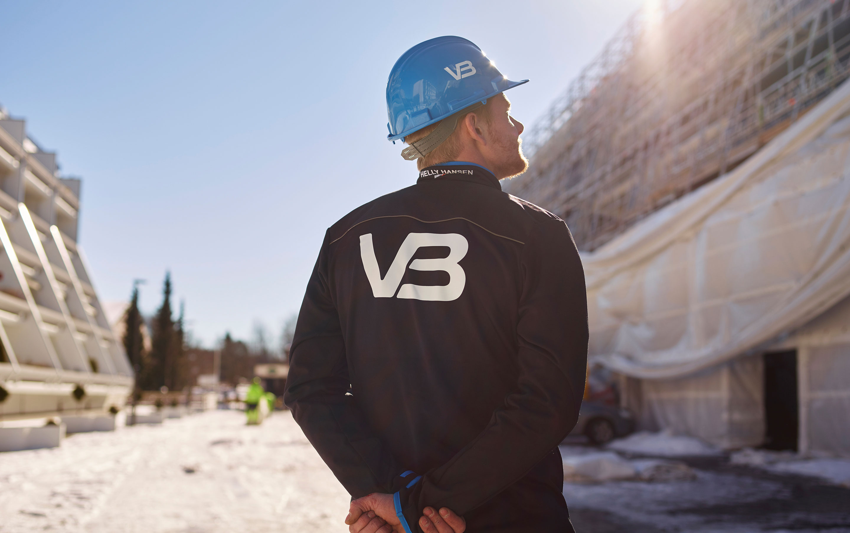 VB Rørlegger med bedriftslogo på baksiden av jakken sin